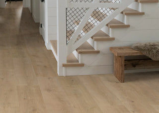 Modern farmhouse stair case featuring Sequoia waterproof European laminate flooring in a natural oak finish in color Empire. Great alternative to vinyl flooring.